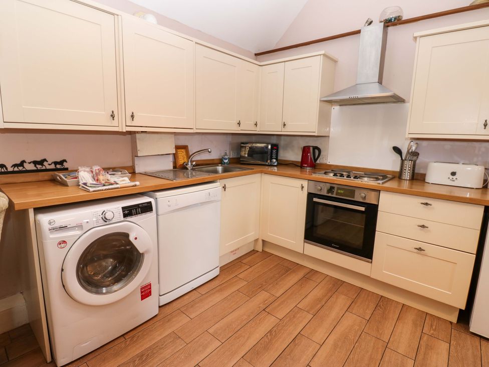 A kitchen with appliances and cabinets at Pottowe Cottage near Stokesley