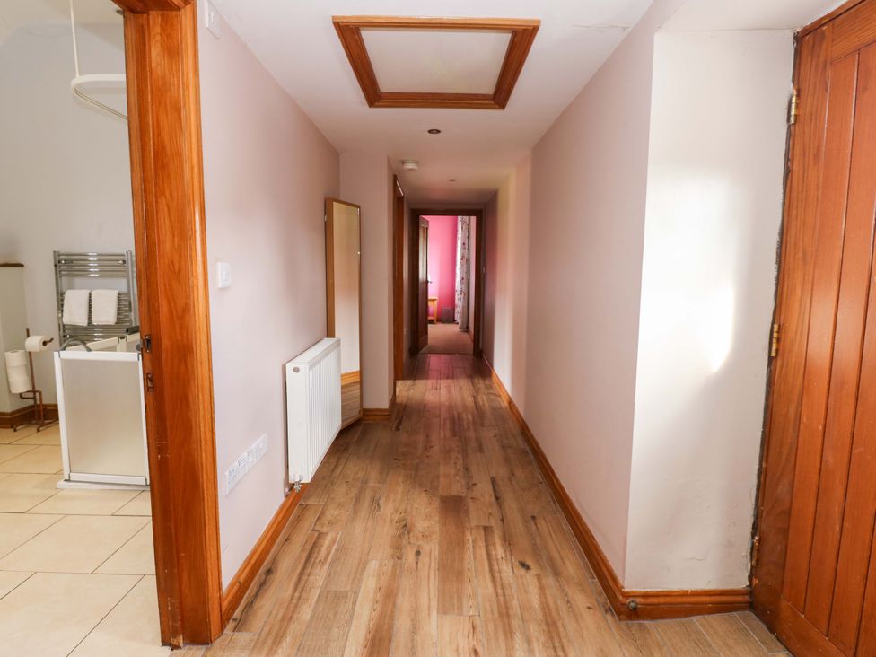 A hallway with a mirror and radiator at Pottowe Cottage in Potto near Stokesley