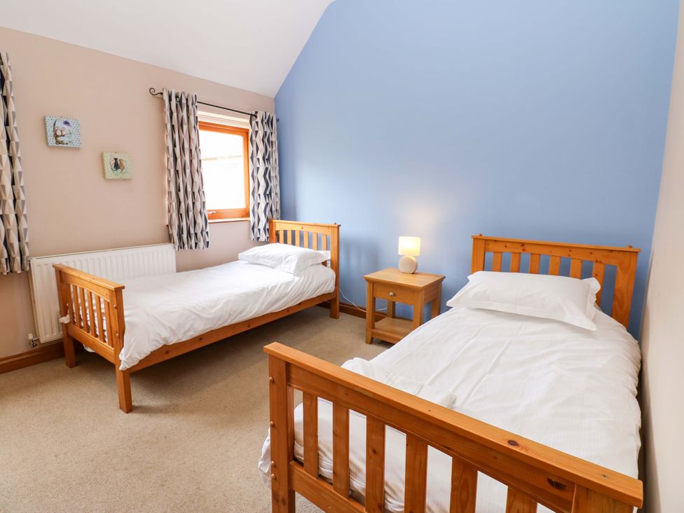 A bedroom with two single beds and a nightstand at Pottowe Cottage in Potto near Stokesley