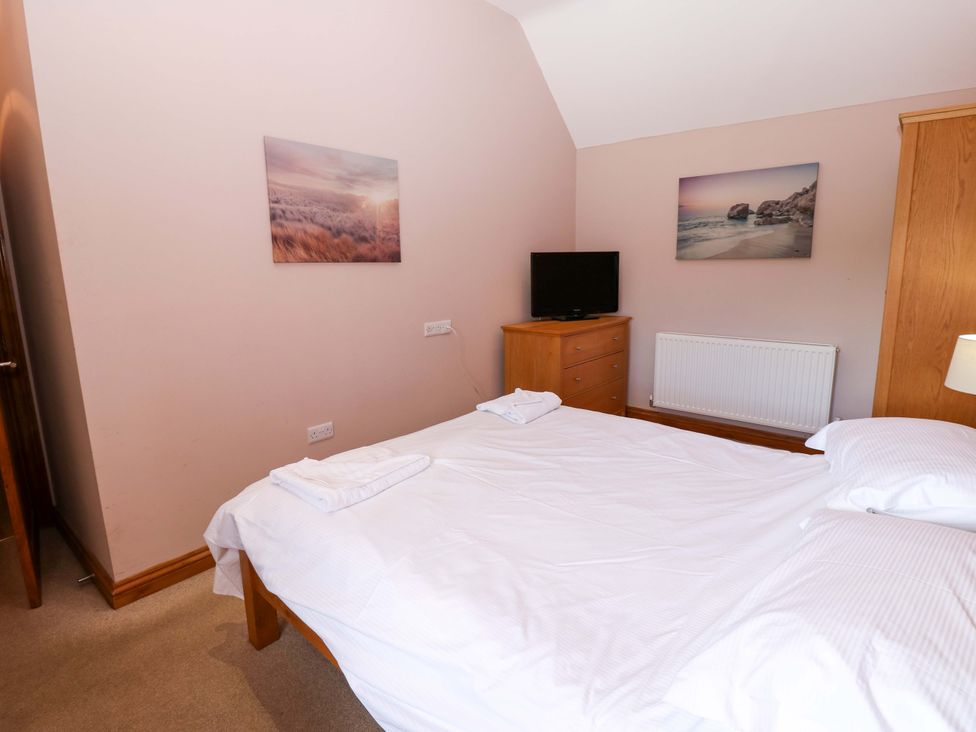 A bedroom with a bed and television at Pottowe Cottage in Potto near Stokesley