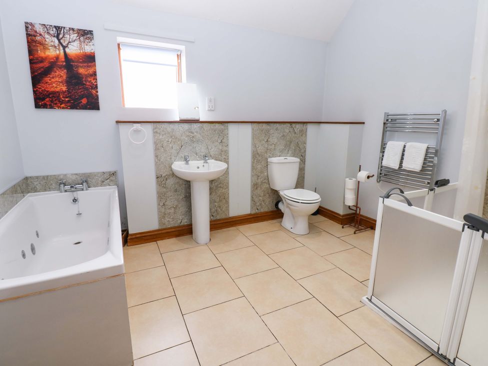 A bathroom with a bathtub, toilet, and washbasin at Pottowe Cottage in Potto near Stokesley