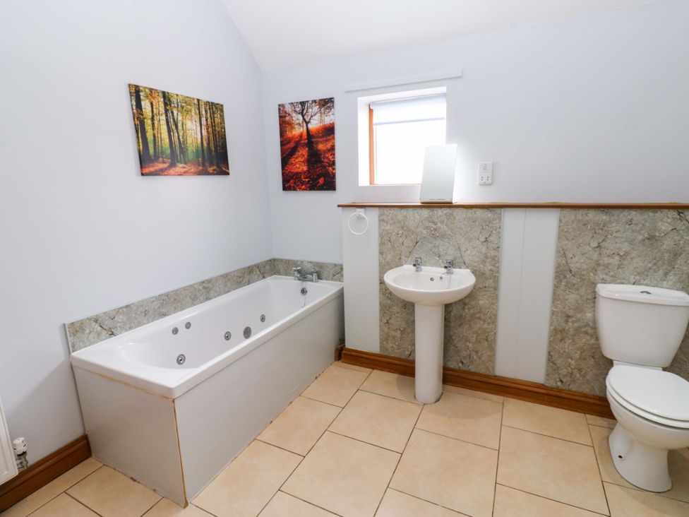 A bathroom with a bathtub, sink, and toilet at Pottowe Cottage near Stokesley