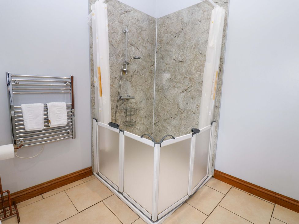 A shower area with towels on a rack at Pottowe Cottage, Potto near Stokesley