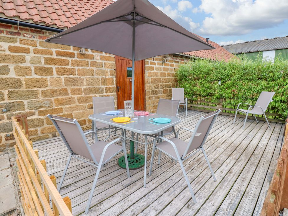 A deck with a table and chairs at Pottowe Cottage in Potto near Stokesley