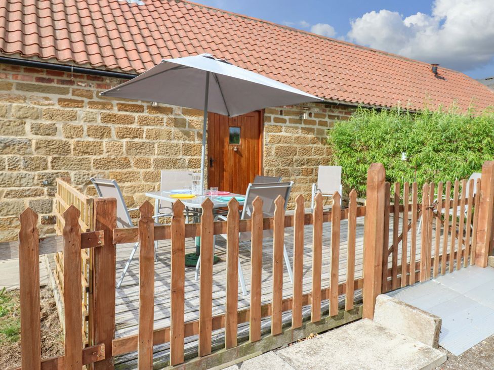 An outdoor patio with a table and chairs at Pottowe Cottage in Potto near Stokesley