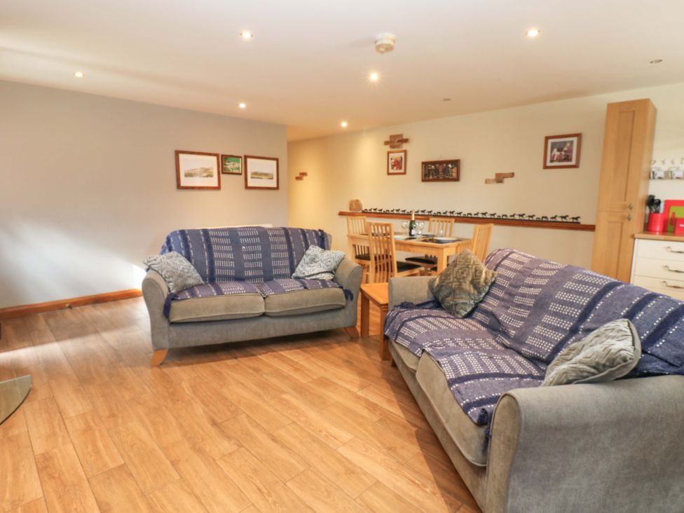 A living room with a sofa and dining area at Cooper Cottage in Potto near Stokesley