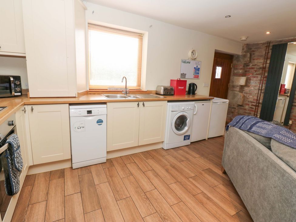 A kitchen with appliances and cabinets at Cooper Cottage in Potto near Stokesley