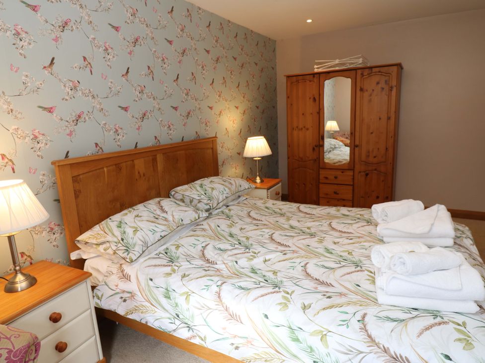 A bedroom with a bed and wardrobe at Cooper Cottage Potto near Stokesley