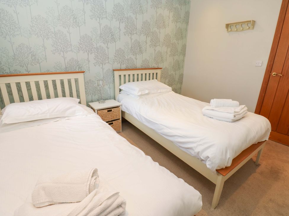 A bedroom with two single beds and a bedside table at Cooper Cottage in Potto near Stokesley