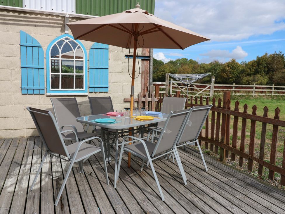 An outdoor seating area with a table and chairs at Cooper Cottage Potto near Stokesley