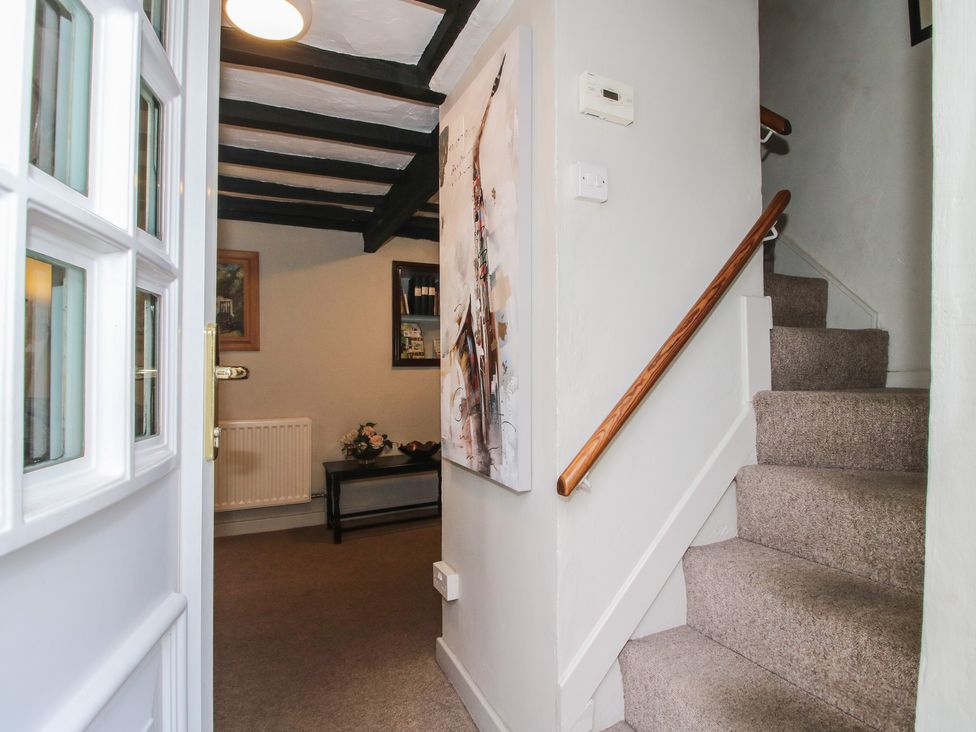 A hallway with a staircase and wall art at Cariad Cottage in Ludlow