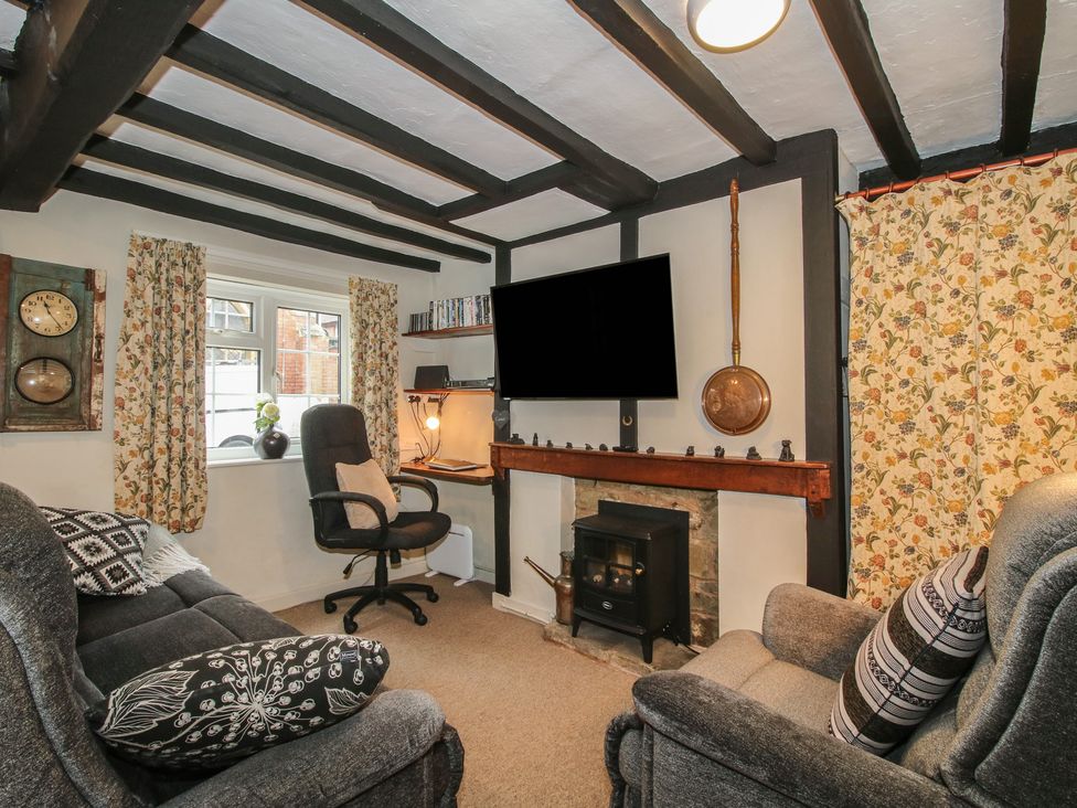 A living room with a fireplace and seating at Cariad Cottage in Ludlow
