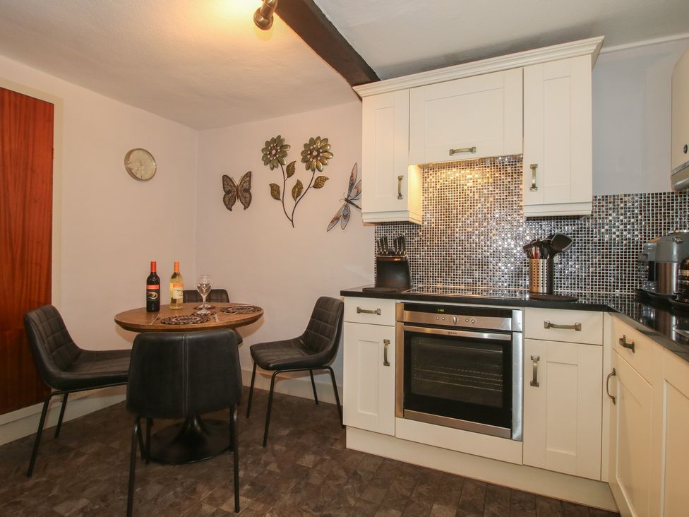 A kitchen with a table and chairs at Cariad Cottage in Ludlow