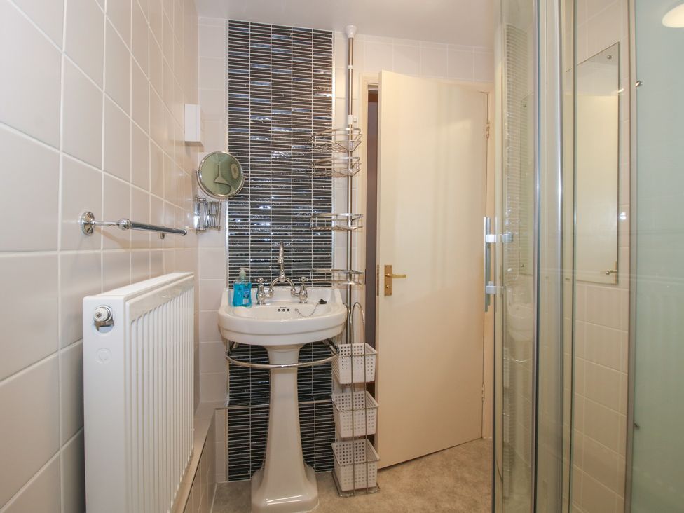 A bathroom with a sink and shower at Cariad Cottage in Ludlow