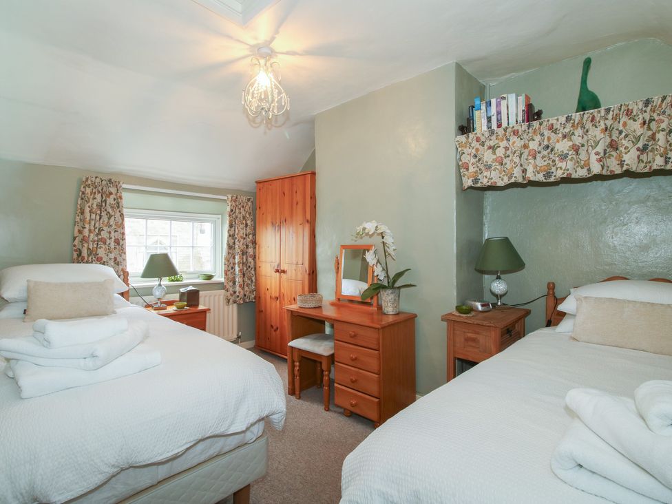 A bedroom with two beds and a desk at Cariad Cottage in Ludlow