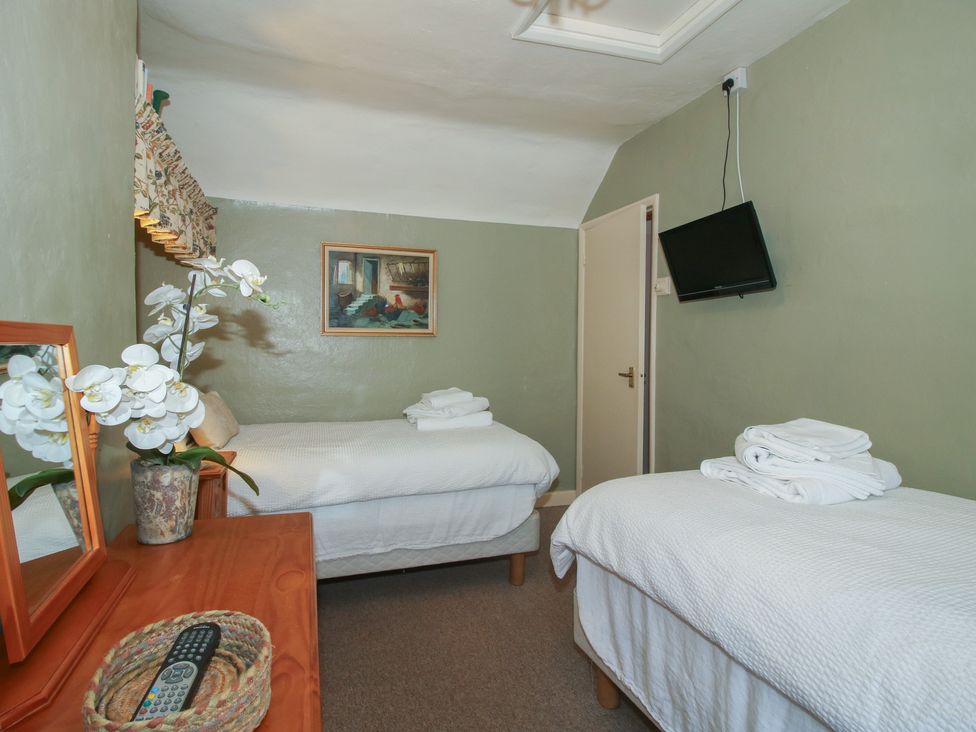 A bedroom with twin beds and a television at Cariad Cottage in Ludlow