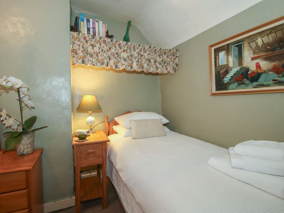 A bedroom with a bed and nightstand at Cariad Cottage Ludlow