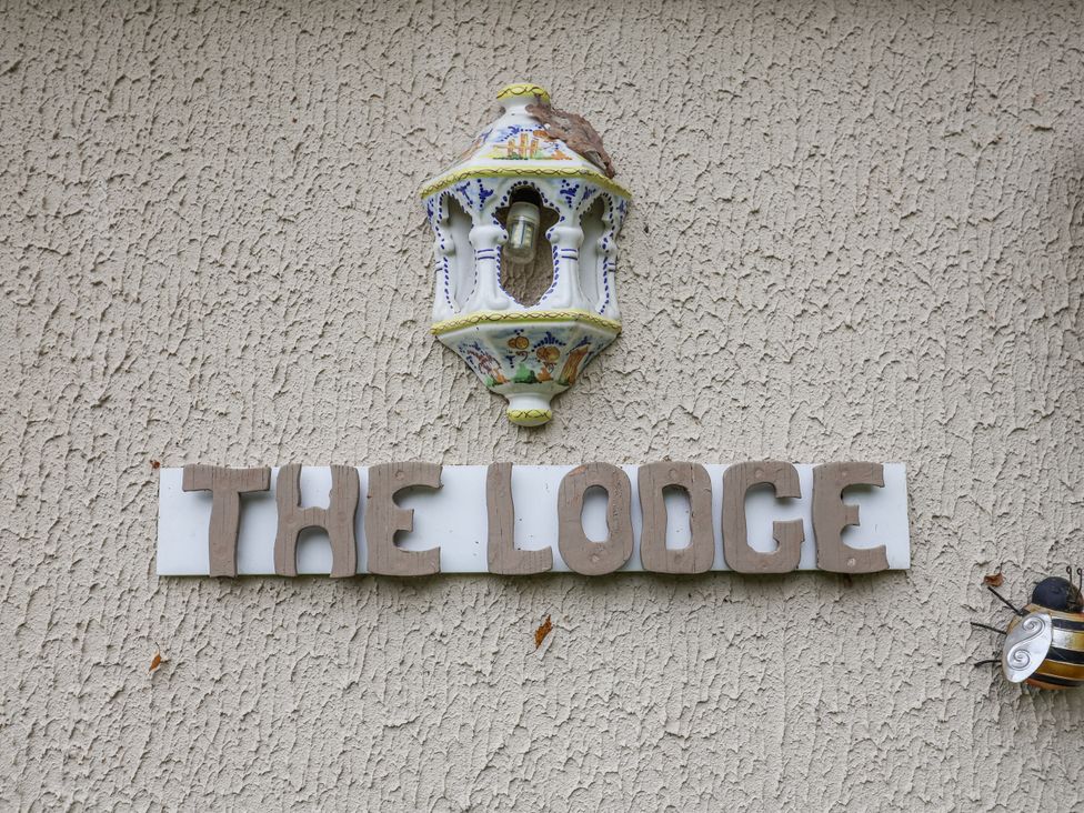 A sign that reads THE LODGE with a light fixture at The Lodge Old Buckenham near Attleborough