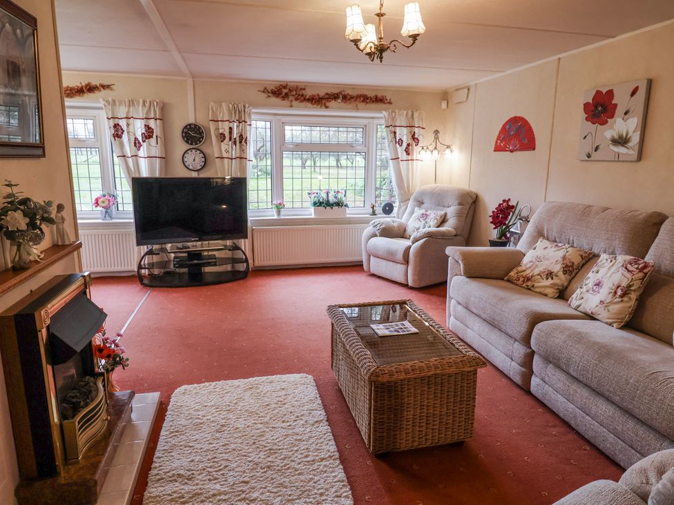 A living room with sofas and a television at The Lodge in Old Buckenham near Attleborough
