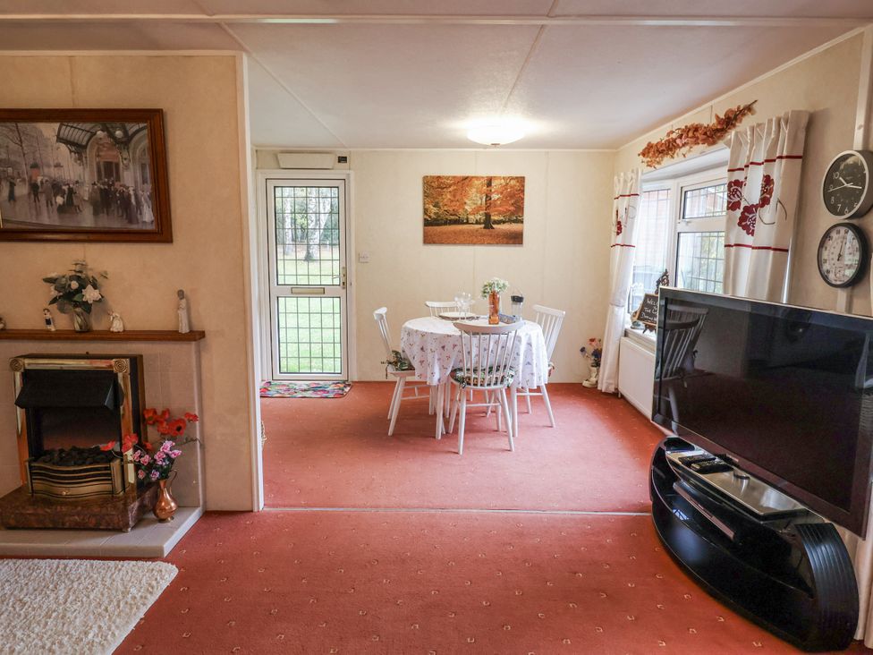 A dining room with a table and chairs at The Lodge in Old Buckenham near Attleborough