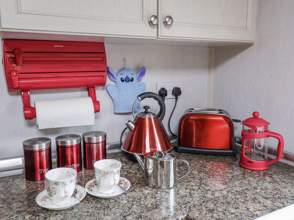 A kitchen counter with a kettle, toaster, cups, and canisters at The Lodge in Old Buckenham near Attleborough