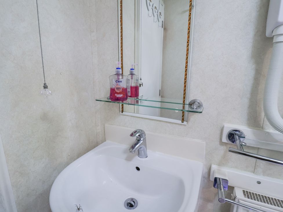 A bathroom with a sink and mirror at The Lodge in Old Buckenham near Attleborough