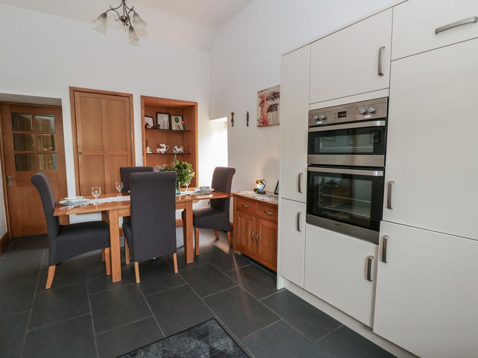 A kitchen with a dining table and chairs at Yr Hen Llaethdy in Blaen-Cil-Llech near Newcastle Emlyn