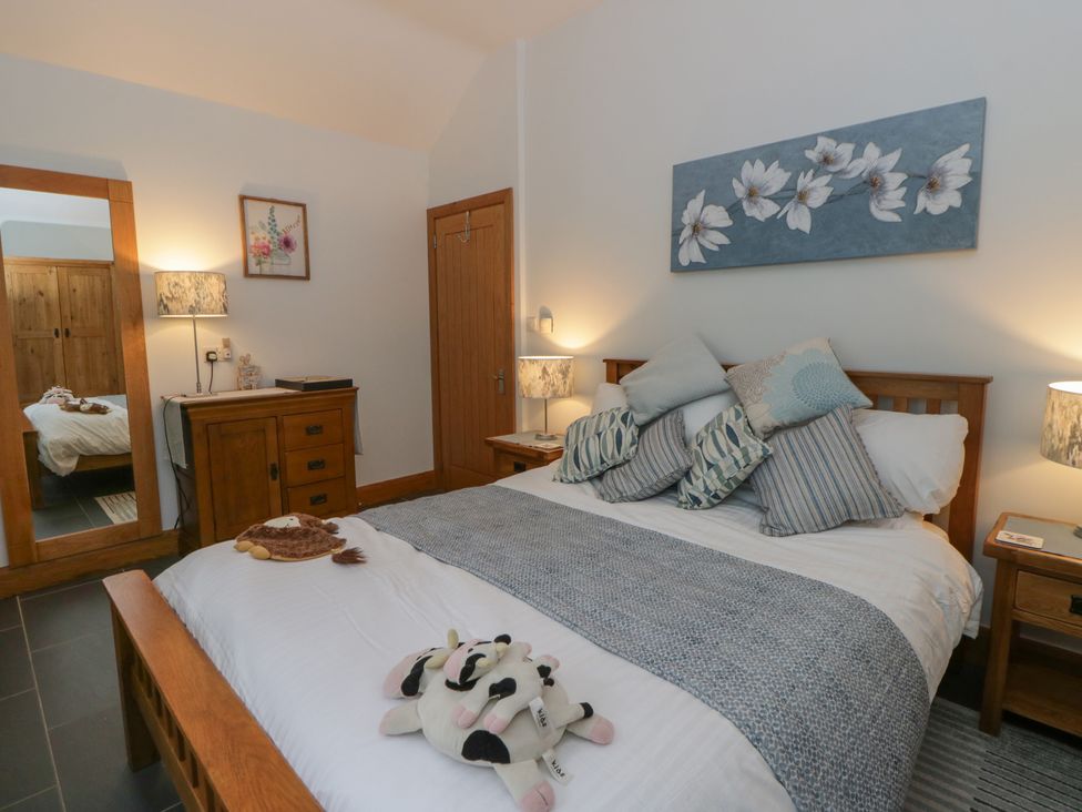 A bedroom with a bed and lamps at Yr Hen Llaethdy in Blaen-Cil-Llech near Newcastle Emlyn