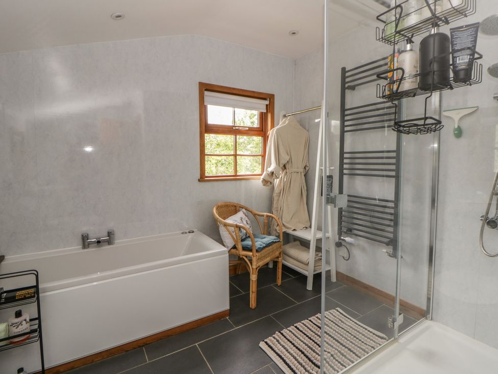 A bathroom with a bathtub and shower at Yr Hen Llaethdy Blaen-Cil-Llech near Newcastle Emlyn