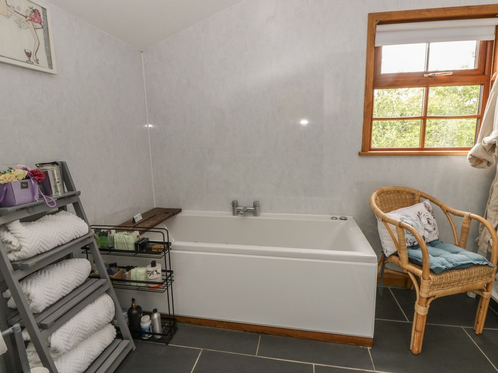 A bathroom with a bath tub and a towel rack at Yr Hen Llaethdy Blaen-Cil-Llech near Newcastle Emlyn