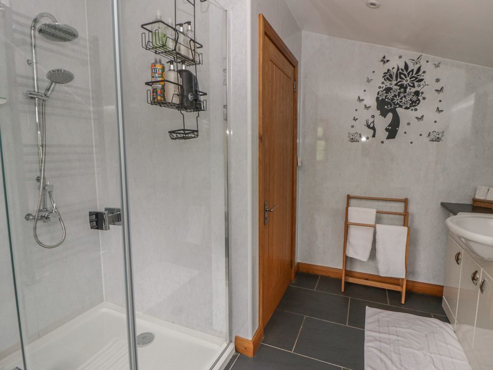 A bathroom with a shower and towels at Yr Hen Llaethdy Blaen-Cil-Llech near Newcastle Emlyn