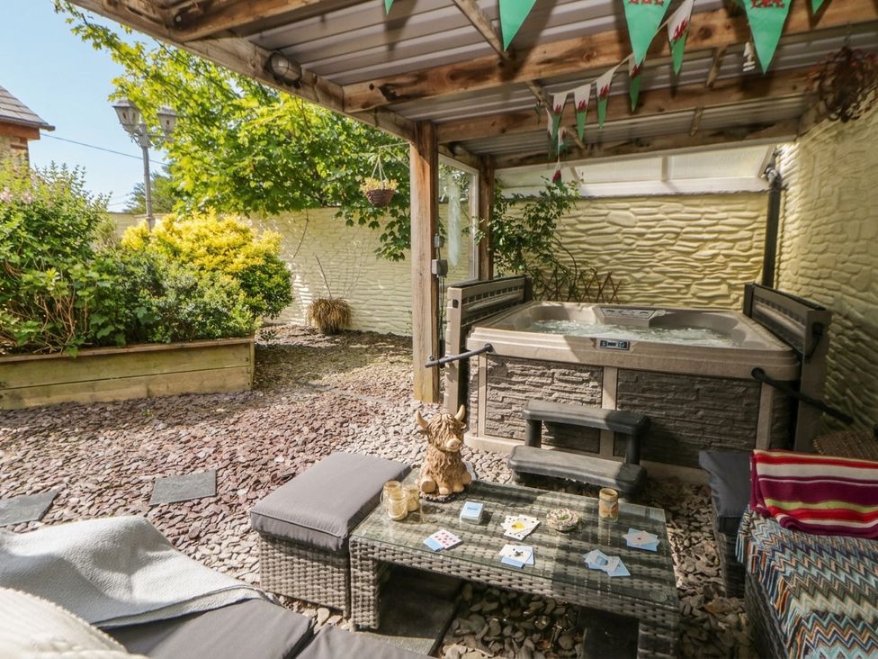 A garden area with a hot tub and outdoor seating at Yr Hen Llaethdy in Blaen-Cil-Llech near Newcastle Emlyn
