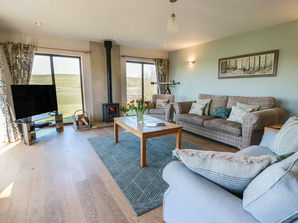 A living room with a television and sofas at South Milton Cottage in Stairhaven near Glenluce