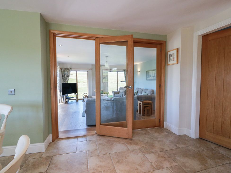 A living room view with a door leading to the outside at South Milton Cottage, Stairhaven near Glenluce