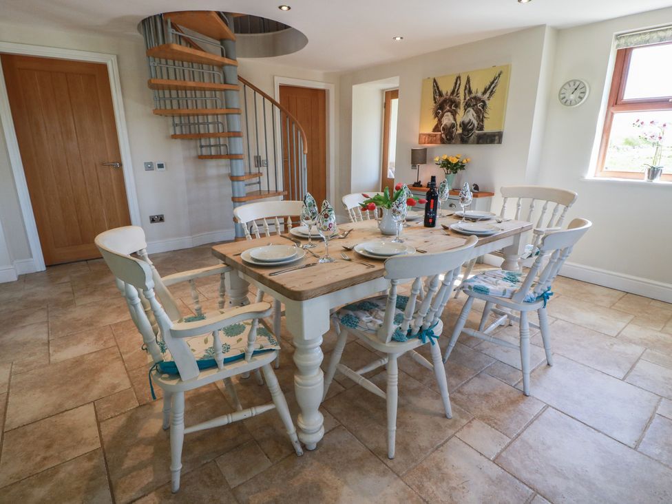A dining room with a table and chairs at South Milton Cottage, Stairhaven near Glenluce