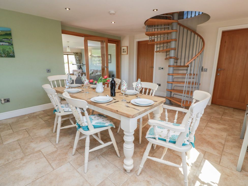 A dining room with a table and chairs at South Milton Cottage Stairhaven near Glenluce