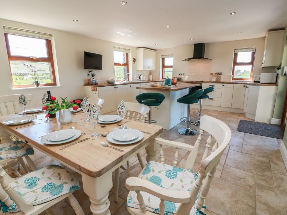 A kitchen with a dining area and appliances at South Milton Cottage Stairhaven near Glenluce