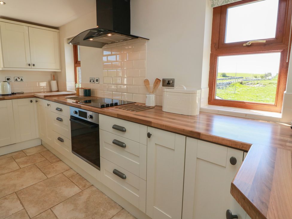 A kitchen with cabinets, oven, and countertop at South Milton Cottage Stairhaven near Glenluce
