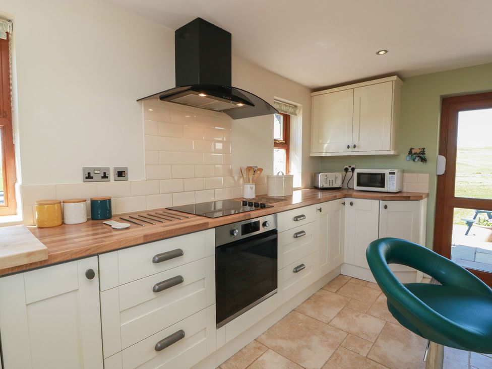 A kitchen with a cooktop and microwave at South Milton Cottage in Stairhaven near Glenluce
