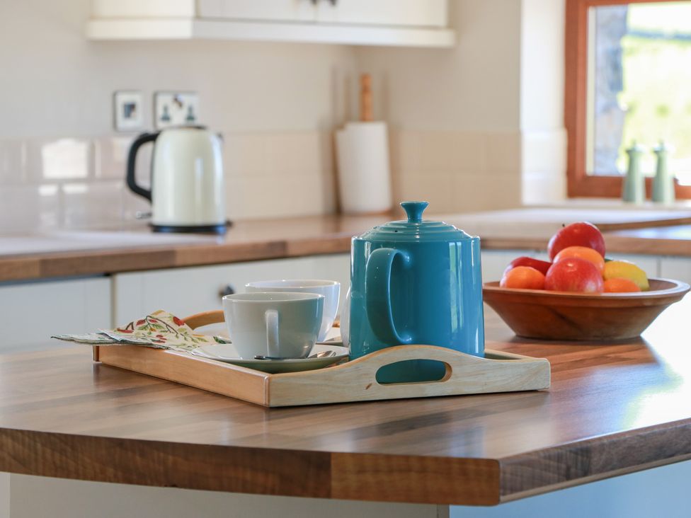 A kitchen with a teapot and cup on a tray at South Milton Cottage Stairhaven near Glenluce