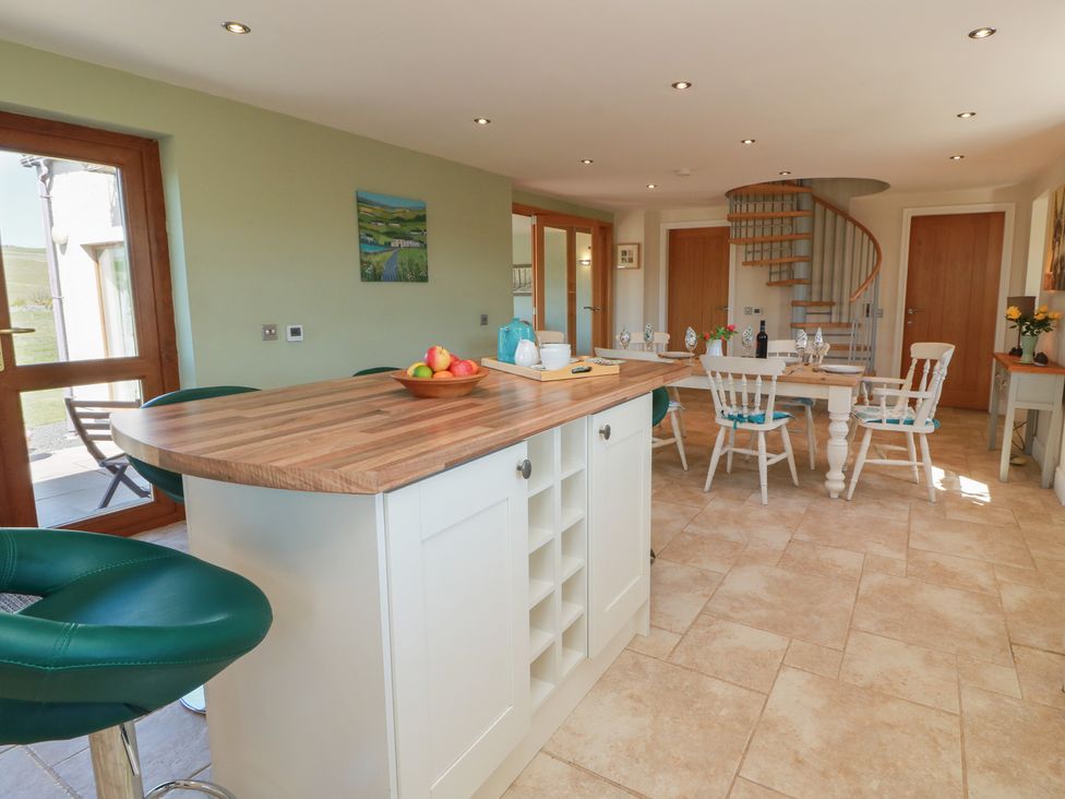 A kitchen with a dining table and chairs at South Milton Cottage Stairhaven near Glenluce