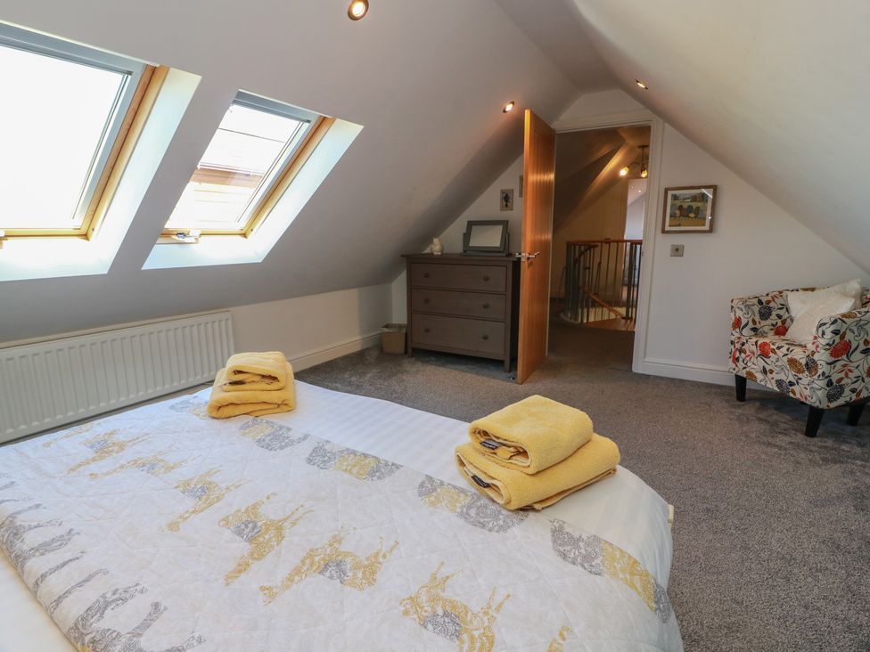 A bedroom with a bed and dresser at South Milton Cottage, Stairhaven near Glenluce