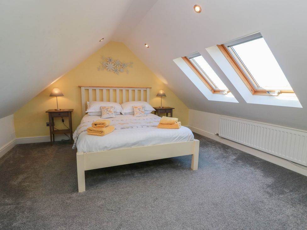 A bedroom with a bed and bedside tables at South Milton Cottage, Stairhaven near Glenluce