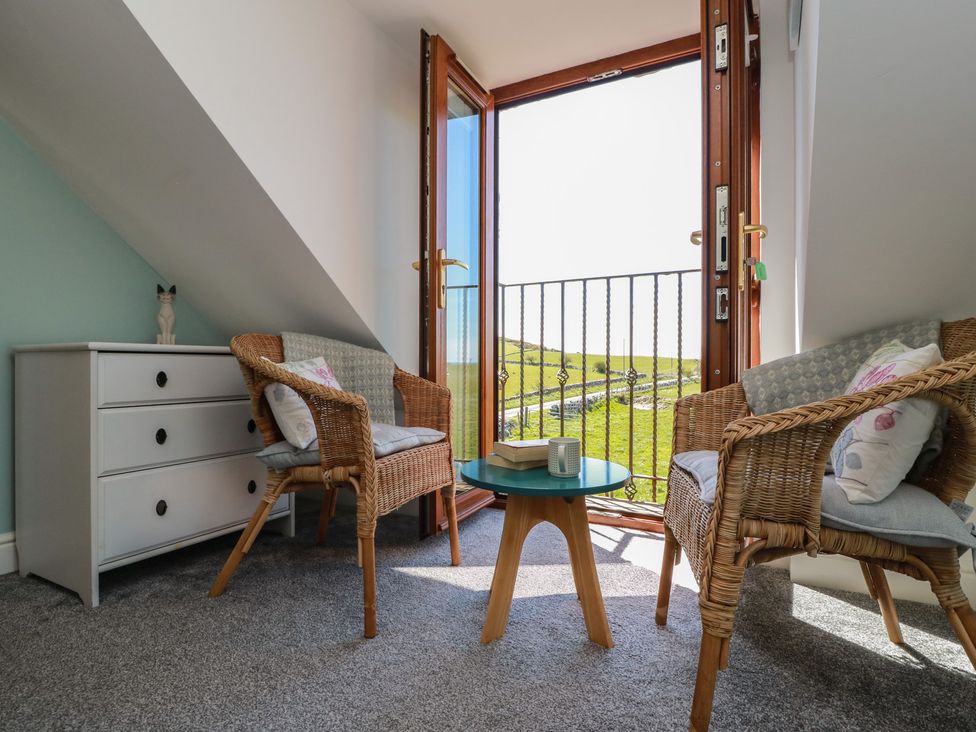 A sitting room with chairs and a table at South Milton Cottage Stairhaven near Glenluce