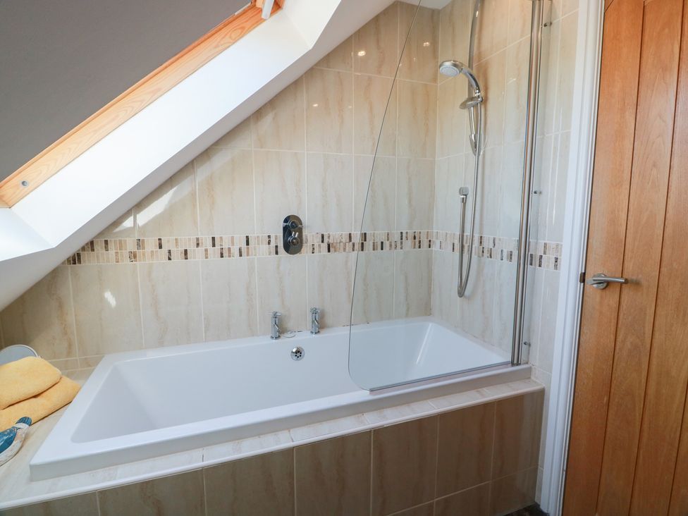 A bathroom with a bathtub and shower at South Milton Cottage Stairhaven near Glenluce