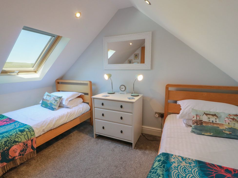 A bedroom with two beds and a dresser at South Milton Cottage in Stairhaven near Glenluce