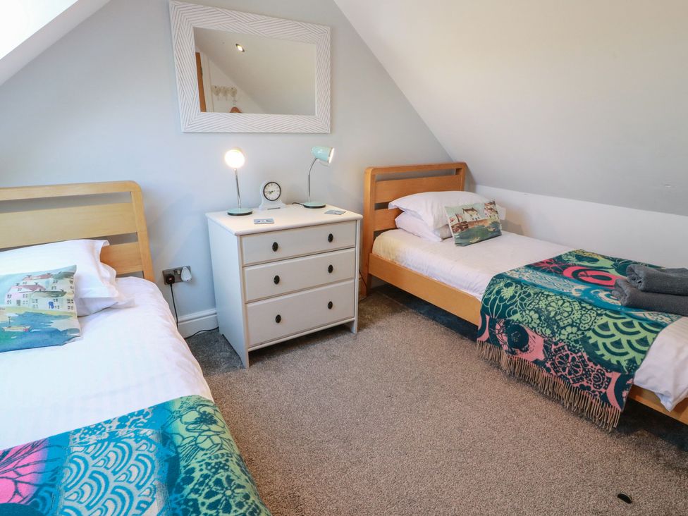 A bedroom with two beds and a nightstand at South Milton Cottage Stairhaven near Glenluce
