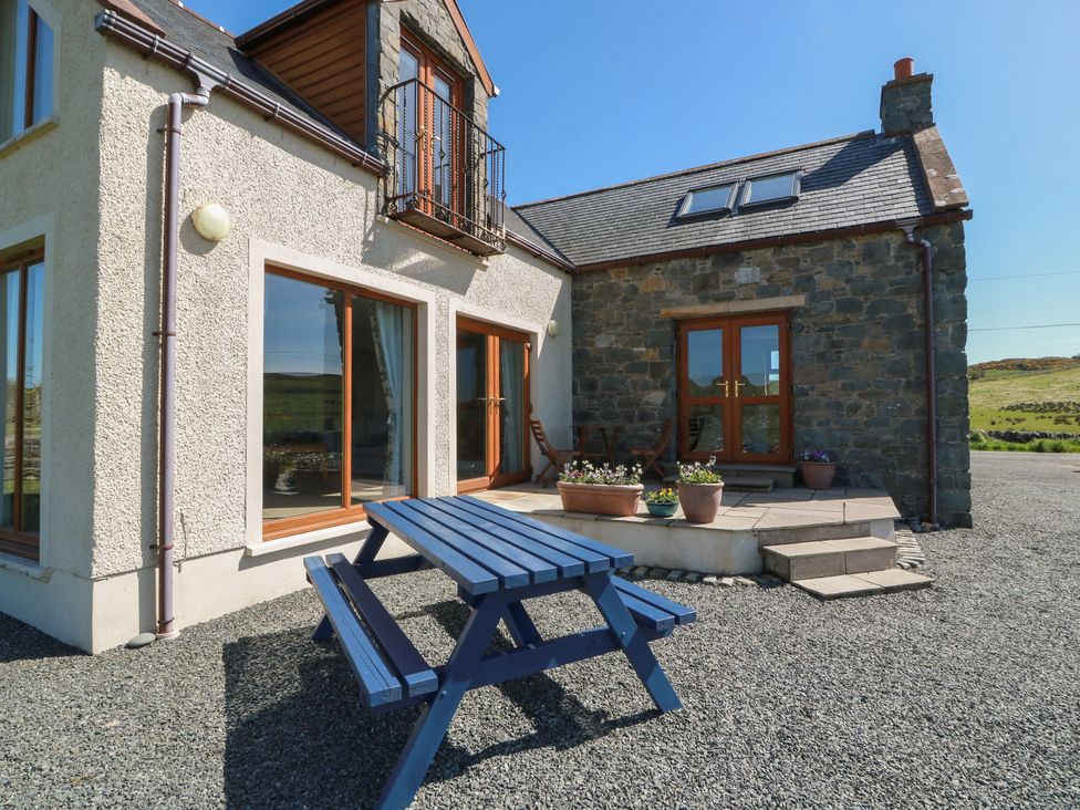 An outdoor seating area with a table and chairs at South Milton Cottage Stairhaven near Glenluce