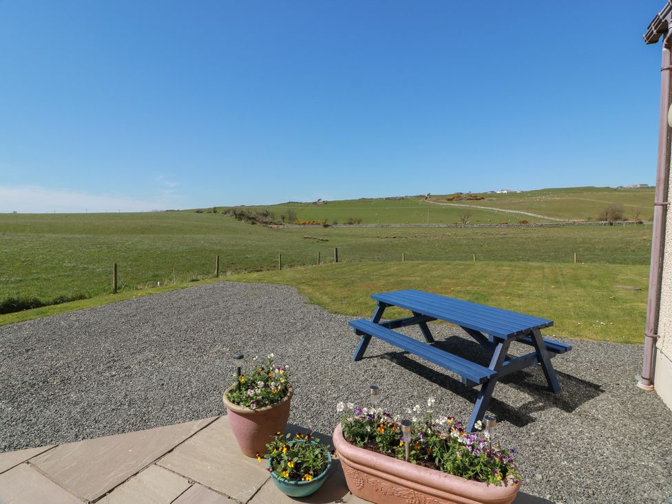 A garden with a blue table and flowers at South Milton Cottage Stairhaven near Glenluce