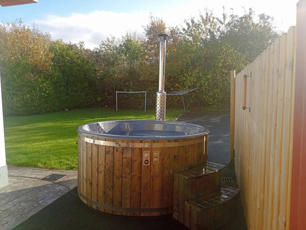 A hot tub with wooden steps in an outdoor area at Kissane's Cottage, Beaufort, County Kerry